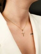 Minimalistyczny krzyżyk z żółego złota z wstawką z białego złota na kobiecej szyi