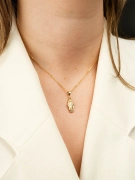 Złoty wisiorek z Maryją zdobiony białym złotem na kobiecej szyi