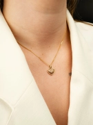 Złoty wisiorek z sercem ażurowym na kobiecej szyi