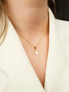 Delikatna zawieszka anioł ze złota w próbie 585 z cyrkoniami na skrzydłach na kobiecej szyi