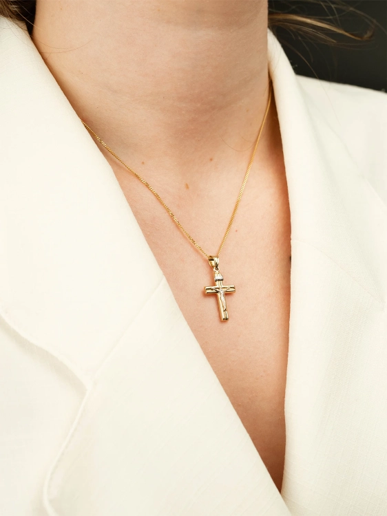 Złoty krzyżyk z Jezusem w żółtym i białym złocie na kobiecej szyi