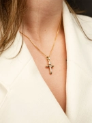 Mały złoty krzyżyk z Jezusem z elementami białego złota na kobiecej szyi