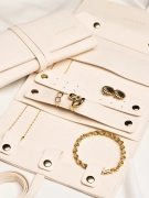 Rozłożone etui na złotą biżuterię, organizery z biżuterią oraz drugie zamknięte etui obok