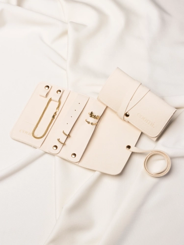 Rozłożone etui na złotą biżuterię, organizery ze złotymi dodatkami oraz drugie zamknięte etui obok